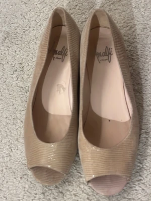 Beige ballerinaskor - Snygga beige ballerinaskor från Amalfi med peep toe och diskret glansig yta. Skorna har 4 cm klack