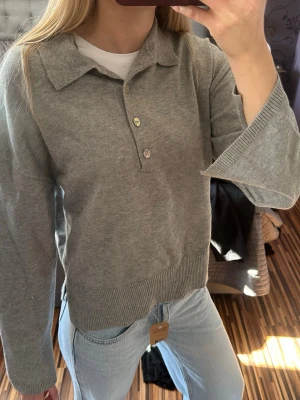Grå stickad tröja med krage Gina Tricot - Grå stickad tröja från Gina Tricot med krage och knappar framtill. Tröjan har utsvängda armar och är endast provad. Nypris 400kr☺️