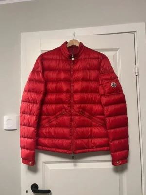 Röd Moncler jacka - Säljer denna jackan då jag ej använder den nån mer. Den är i storlek L men passar även M