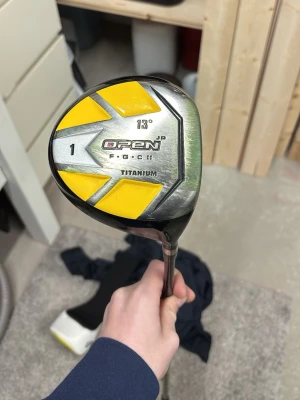 Golfklubba Open JR Titanium Driver - Golfklubba driver med 13° loft från Open JR, modell F-GC II. Klubban har ett huvud i titan med silver och gula detaljer samt svart skaft med gula inslag. Perfekt för dig som vill ha en cool och lätt driver till golfbanan. Obs kan inte sicka via instabox