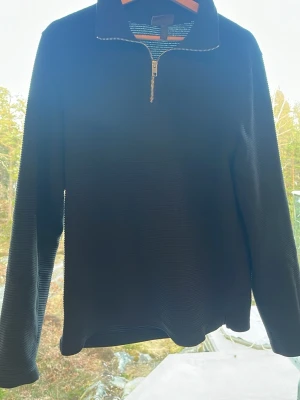 Svart halvzip tröja från H&M - Säljer en svart långärmad tröja från H&M med halv dragkedja och ståkrage. Regular fit och diskret ribbad struktur i tyget. Perfekt för dig som gillar enkel och stilren design. I storlek S, finns en liten defekt på höger arm (se på sista bilden)