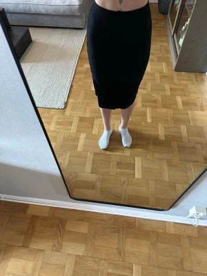 Svart ribbad midikjol med slits - Svart midikjol från Only med ribbad struktur och slits på sidan. Kjolen har en tight passform. Använd endast 2/3 gånger. Jag är 168cm