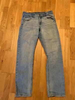 Ljusblå jeans  - Ljusblå jeans med rak passform och 4 fickor. Jeansen har en klassisk design med normal midja och dragkedja med knapp. Tillverkade i denim med lätt tvättad look. Perfekta för en avslappnad stil.