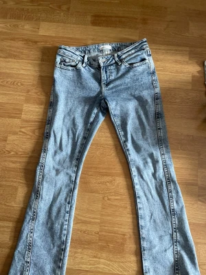 Blåa jeans  - Säljer ett par snygga lågmidjade blåa jeans från Gina Tricot i storlek 34. Jeansen har snygga broderade bakfickor. Säljer pga att de är lite förstora och långa. Använda några fåtal gånger, men är lite slitna längst ner vid fötterna. Nypris 500 kr💕