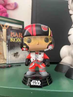 Star Wars pilot hjälmfigur - Cool Star Wars hjälmfigur från Funko Pop föreställande en rebellpilot i röd och svart hjälm med gula visirglas och detaljerad overall. 