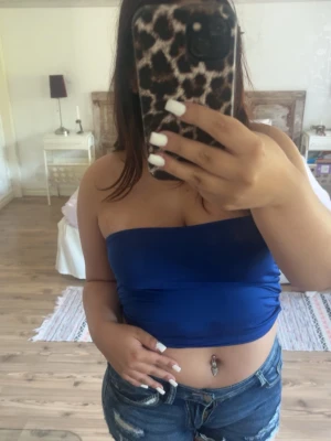 Blå bandeau tubtopp - Säljer en enkel och snygg blå bandeau tubtopp. Toppen är axelbandslös och har en tight passform som sitter på plats. Perfekt till sommaren och lätt att matcha med olika stilar.