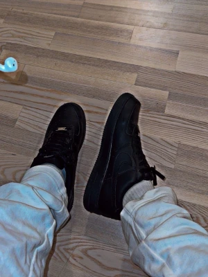 Svarta AF1 - Svarta Nike Air Force 1 sneakers perfekt conditon och helt äkta. Aldrig använt