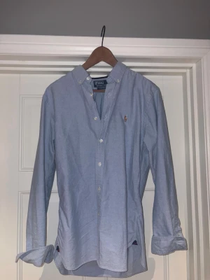 Blå skjorta från Polo Ralph Lauren storlek M - Klassisk ljusblå skjorta från Polo Ralph Lauren riktigt snygg o passar bra nu till sommaren