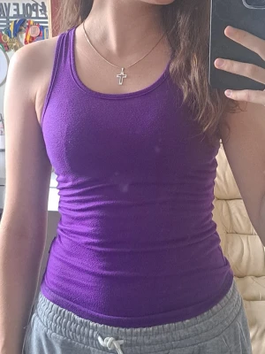 Lila linnetopp från Cubus - Snygg lila linnetopp från Cubus i mjuk bomull. Modellen är tight och ärmlös. Märkte när jag tog närbilder att den hade en fläck, hade inte märkt annars. Men p.g.a. det så blir det rabatt.