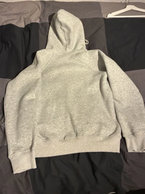 Ljusgrå zip hoodie med huva - Säljer en ljusgrå hoodie med dragkedja och huva. Hoodien har dragsnören i huvan och ribbade muddar vid ärmslut och nederkant. Tillverkad i mjukt sweatshirtmaterial, perfekt för chill dagar. Inga synliga loggor eller tryck.