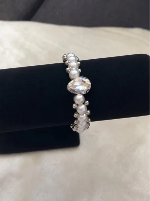 Pärlarmband med stor kristall -  armband med vita pärlor och en stor glittrande kristall i mitten. 