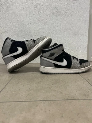 Air Jordan 1 Mid Elephant Print - Jag säljer ett par Jordan skor i storleken 39. Nypris är cirka 1300 kr. De är svarta med vitt och grått mönster lite över allt. Bara att skicka om du har fråga/ diskutera pris.