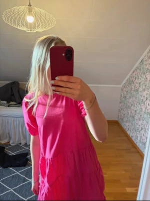 Rosa klänning - Säljer en söt rosa kort klänning med puffärmar. Klänningen har volangdetaljer och är super fin!