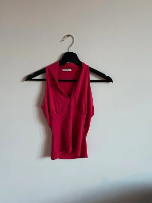 Rosa ärmlös topp från the point - Snygg rosa topp från the point med v-ringning och figurnära passform. Toppen är ärmlös och croppad, perfekt till höga byxor eller kjol. Tillverkad i mjukt material som känns skönt mot huden.