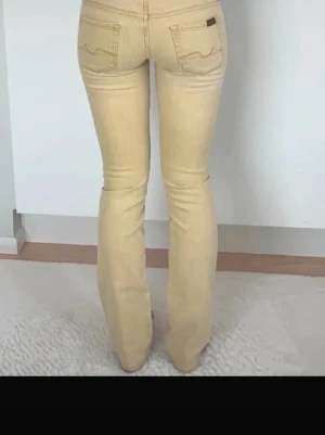Beige bootcut jeans från 7 for all mankind - Snygga beige bootcut jeans från Lee med klassiska fem fickor och diskret logga på bakfickan. Jeansen har en smal passform upptill och lätt utsvängda ben. Tillverkade i mjukt denimtyg som ger en bekväm känsla och trendig look.