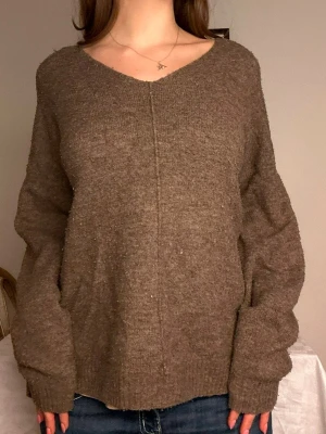 Brun oversized stickad tröja🤎 - Mysig brun stickad tröja med v-ringning och avslappnad, oversized passform. Tröjan har en dekorativ söm framtill och ribbade muddar vid ärmslut och nederkant. Perfekt för lager på lager och chill dagar. Lite smånopprig som lätt tas bort med en avnopprare🤎