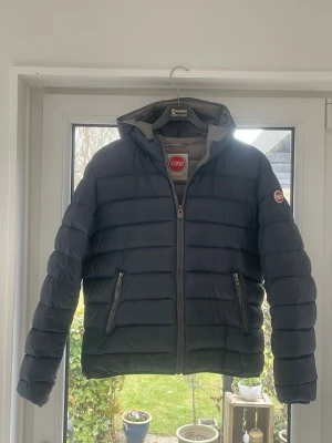 Colmar jacka - En fin jacka från colmar. Jackan är i stlk S/M och är i färgen blå. Jackan har ett litet hål i armen på 2cm som är ihop sytt och inte något man märker