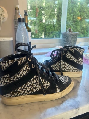 Zadig & Voltaire skor - Super snygga sneakers från Zadig & Voltaire. Skorna har lite skavanker bland annat lite märken på sulan som syns på bilden. Har köpt till skosnörerna som sitter på, de original är helt svarta. Skickar såklart med båda två. Har kvar dustbag, original kartong och påsen för skosnörerna. Brukar ha strl 38 i skor men dessa är lite större. 