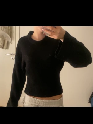 Svart stickad tröja - Svart stickad tröja med croppad passform och långa ärmar ifrån Gina tricot. Använd en gång. 