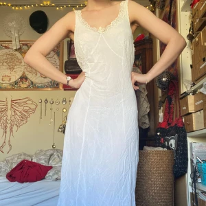 Vit spetsklänning / nattlinne - sött vitt nattlinne med spetsdetaljer vid halsringningen axelbanden och längst ned. väldigt mjuk men för stor för mig. går ned till under knäna. stl L, speciellt i bysten. tre små hål nere framtill och en liten slitning vid midjan. 