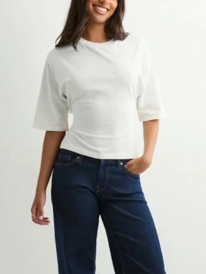 Vit croppad topp med knyt i ryggen från Nelly - Säljer denna snygga toppen från Nelly med öppen rygg. Toppen är aldri blivit anvendt och har fortfarande prislappen på. 