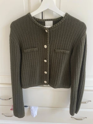 Olivgrön stickad kofta från H&M - Snygg olivgrön stickad kofta från H&M. TVEKA INTE OM FRÅGOR!🩷Pris kan diskuteras🌼🌸Den är i storlek M men jag skulle säga att den är S. Passar mig som är xs/s. 