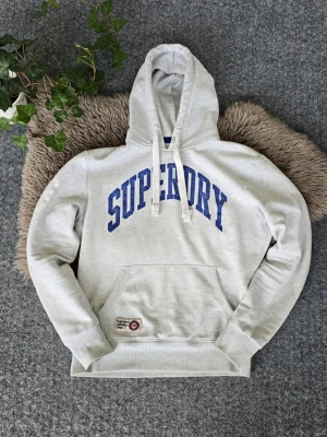 Superdry hoodie - Superdry hoodie i storlek Medium. Mycket bra skick förutom att trycket är lite slitet, men enligt mig är det lite coolt. Skriv om du undrar något.