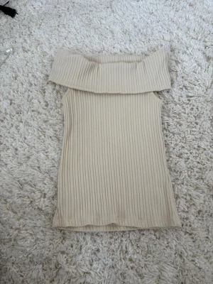 Beige ribbad offshoulder topp Gina Tricot - Säljer en beige ribbad offshoulder topp från Gina Tricot i storlek XS. Endast använd fåtal gånger så som ny!💕