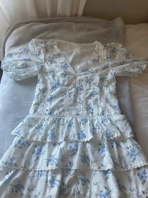 Blommig kortklänning med volanger - Fin sommarklänning med blommigt mönster. Perfekt till somriga dagar. 