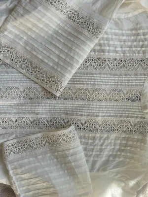 Krämvit blus med spetsdetaljer - En jättefin krämvit blus från H&M som har knappar men även ett knyte där bak längstner. Säljer pga att jag har växt ur den, och strlk står inte, men är i storlek S/36 skulle jag säga och den är i super bra skick då den använts 2 gånger❣️