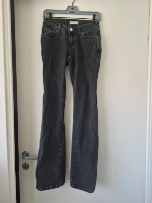Svarta bootcut jeans från Gina Tricot - Snygga svarta bootcut jeans från Gina Tricot med klassisk femficksmodell och vita sömmar. Jeansen har låg midja och utsvängda ben som går ut lite nedtill. Tillverkade i kraftigt denimtyg som ger en cool vintagekänsla.