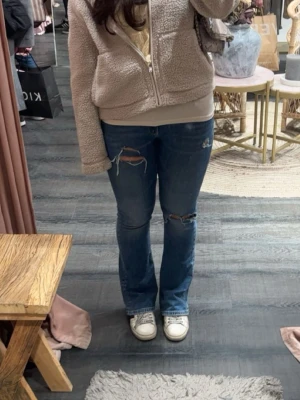 Blå slitna bootcut jeans - säljer ett par blå slitna bootcut jeans!