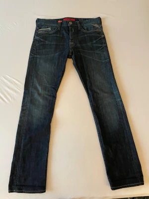 Mörkblå jeans från Levi's - Säljer ett par klassiska mörkblå jeans från Levi's med fem fickor och raka ben. Jeansen har snygga kontrastsömmar och en diskret tvättad look. Perfekta till vardags och passar till det mesta. Levi's-logga på bakfickan. Nypris 1499. 
