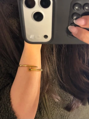 Guldigt armband i spikdesign - Snyggt armband i guldfärgad metall med unik spikformad design. Rostfritttål