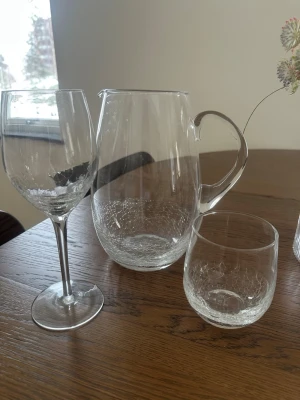 Sia set  - Säljer ett siaset med en karaff, ett vinglas och ett dricksglas i klarglas. Alla delar har ett snyggt sprucket mönster i botten som ger en unik look. Perfekt till servering av dryck och snygga att ha framme på bordet. Glasen är 35 cl