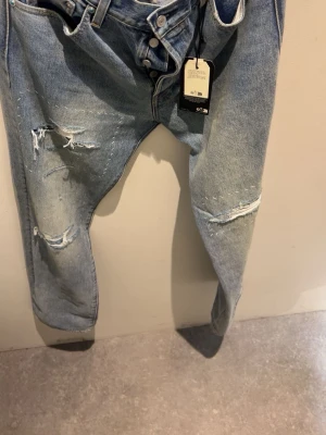 Levi's ljusblå ripped jeans Selvedge - Säljer ett par helt nya selvedege Levis jeans med unika slitningar med prislapp på och alla tags helt nya.