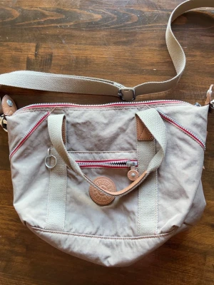 Kipling axelväska  - Snygg axelväska från kipling. Skulle säga att färgen är beige/lite khaki. Säljer då den inte används längre 🌟