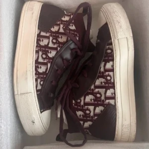 Bordeaux Dior sneakers med monogram - Snygga sneakers från Dior. Strl 36,5 men de är större i modellen så passar nån strö större mycket bra är en 38. bilderna är suddiga då jag screena från min vinted där de ligger uppe. Skriv för fler bilder köpt från vestsire där det var genom än äktahets kontroll men kvitto och allt sånt medföljer dessutom från original butik.