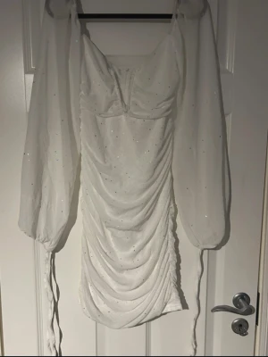 Vit glittrig klänning med puffärmar - Vit kort klänning med glittriga detaljer som fångar ljuset så fint. Puffiga långärmar, v-ringning som ger en figurnära passform. En perfekt klänning till fest, middag, student eller speciella tillfällen 🤍(ifrån shein)