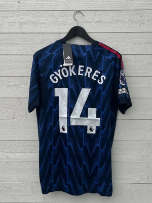 Viktor Gyökeres Arsenal Fotbollströja - Säljer en Arsenal fotbollströja med Gyökeres 14 på ryggen som är helt ny med prislapp!