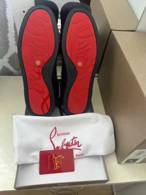 Christian Louboutin sneakers navy - Snygga sneakers  Christian Louboutin i mörkblå mocka med ikoniska röda sulor . Kan diskutera om pris