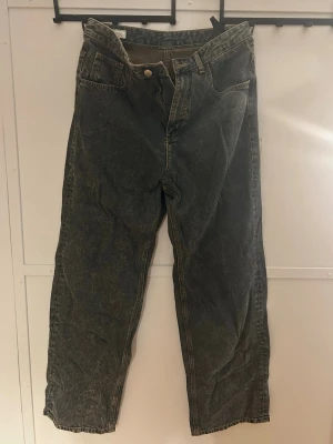  loose fit jeans med hög midja från Zara - Säljer ett par loose fit jeans med hög midja och raka ben. Jeansen har klassisk femficksdesign och knappgylf. Materialet är kraftig denim i bomull med en tvättad look som ger en vintagekänsla. Jeansen är från Zara