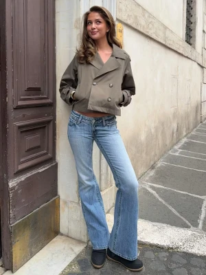 Ljusblå bootcut jeans med låg midja - Säljer ett par ljusblå bootcut jeans med låg midja och slitna detaljer vid benslut. Jeansen har klassisk femficksmodell och är tillverkade i denim med lätt tvättad look. Perfekta för en avslappnad och trendig stil. Endast andvända en gång!