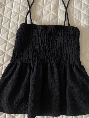 Svart linnetopp Gina Tricot - Säljer en svart linnetopp från Gina Tricot med smockad överdel och tunna axelband. Toppen har en volangig nederdel. Perfekt nu till vår och sommar. Pris går att diskutera🙃