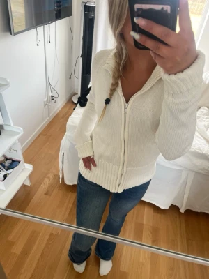 Vit stickad kofta med dragkedja - Mysig vit stickad kofta med dragkedja. Säljer då den aldrig kommit till användning. Storleken är M men passar även väldigt bra för S/XS