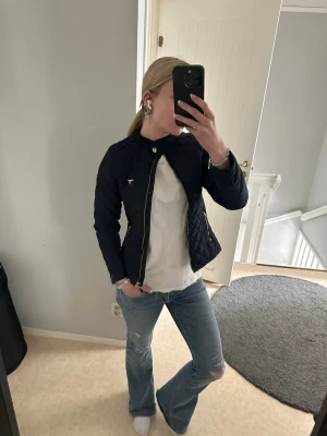 Mörkblå quiltad jacka Hampton Republic - Snygg mörkblå quiltad jacka från Hampton Republic med guldfärgade knappar och dragkedja. Storlek 152, men funkar annars för längre om man vill ha en kort passform!