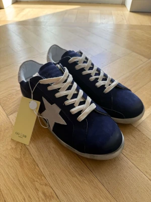 Golden Goose sneakers - Hej! Säljer ett par blå Golden Goose sneakers i storlek 42. Skorna är i nyskick och har kvar taggen på sig. Till skorna medföljer originallåda.