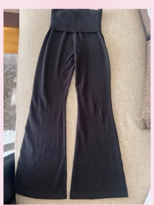 Svarta ribbade leggings med utsvängda ben - Säljer ett par svarta leggings med hög ribbad midja och utsvängda ben. Mjukt och stretchigt material som sitter skönt på kroppen. Perfekta för en avslappnad och trendig look.