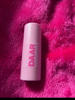 DAAR Blush Darling stick - Krämrouge i stickformat från DAAR i färgen Darling. Förpackningen är ljusrosa med tydlig logga och innehåller 8g produkt. Enkel att applicera direkt på kinderna för en fräsch look. Tillverkad i Italien.