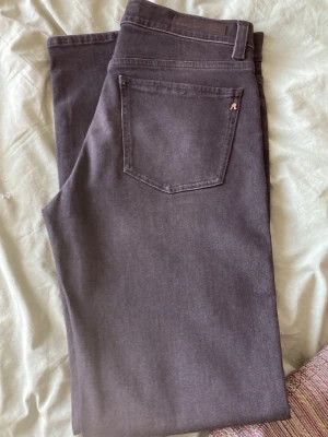 Replay jeans  - Snygga mörkgrå jeans från Replay med klassisk femficksmodell och raka ben. Jeansen har en diskret logga på bakfickan och är tillverkade i ett mjukt denimtyg som ger en skön känsla. Perfekta för en avslappnad och trendig stil.